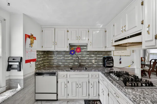 a kitchen with stainless steel appliances granite countertop a stove and cabinets
