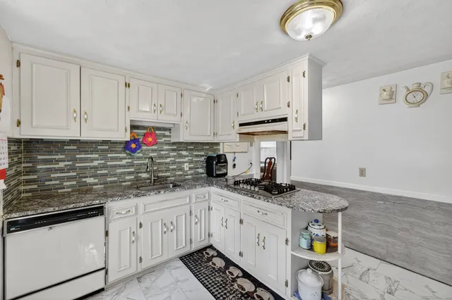 a kitchen with stainless steel appliances granite countertop a sink a stove and cabinets
