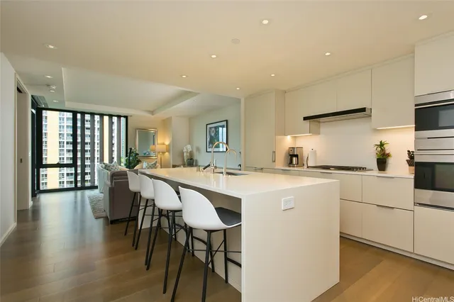 a kitchen with stainless steel appliances a dining table chairs and wooden floor