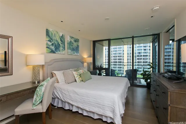 a bedroom with a large bed and large windows