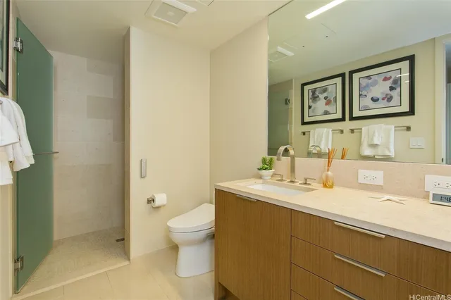 a bathroom with a granite countertop sink mirror vanity and toilet