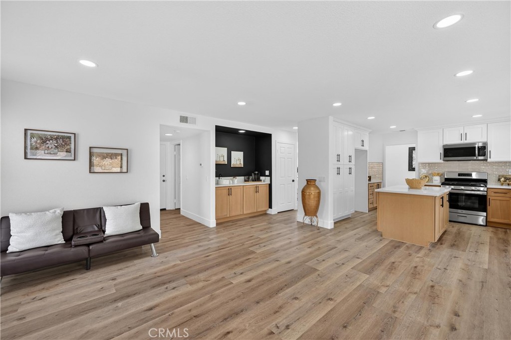 21484 Dickinson Road Moreno Valley, CA 92557 - Photo 20 of 48 a living room with furniture and kitchen with a wooden floor
