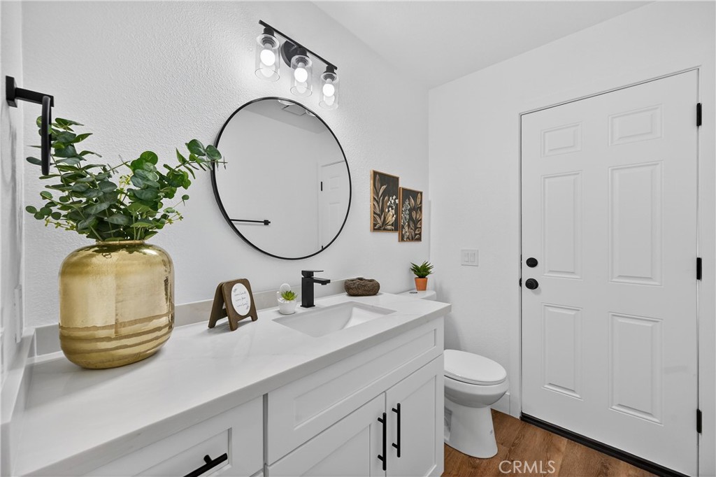 21484 Dickinson Road Moreno Valley, CA 92557 - Photo 23 of 48 a bathroom with a toilet a sink and mirror