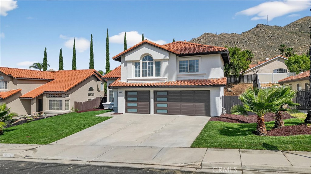 21484 Dickinson Road Moreno Valley, CA 92557 - Photo 3 of 48 a front view of a house with a yard and garage