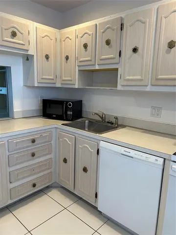 a kitchen with white cabinets and white appliances