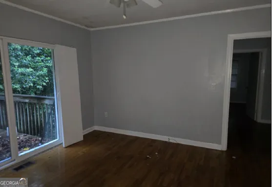 a view of a small space with wooden floor and a window