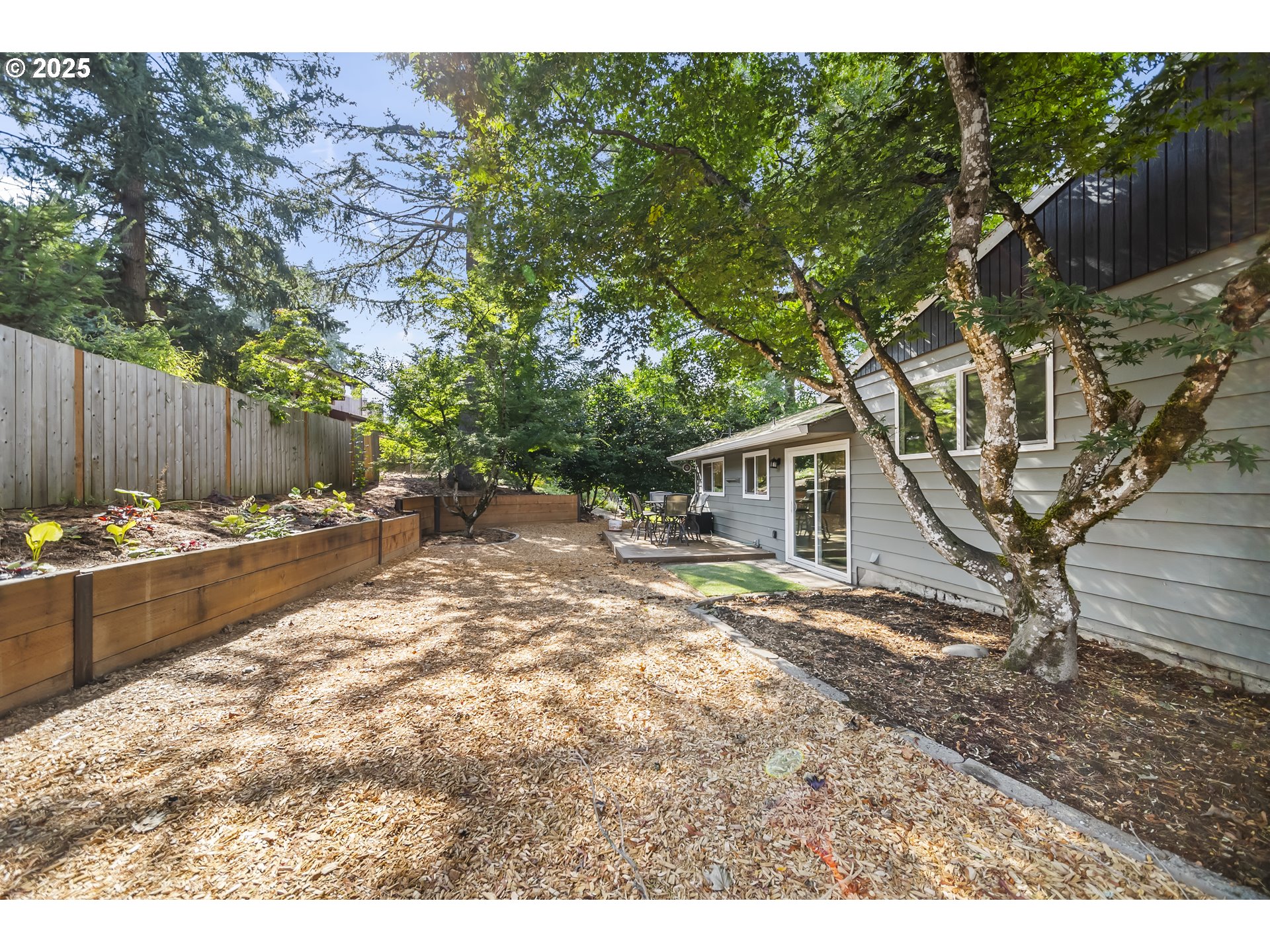 712 Southwest 4th Street Gresham, OR 97080 - Photo 41 of 47 a view of a backyard with large trees and wooden fence