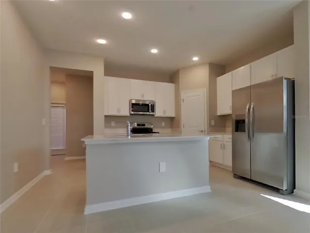 a kitchen with stainless steel appliances a refrigerator sink and microwave
