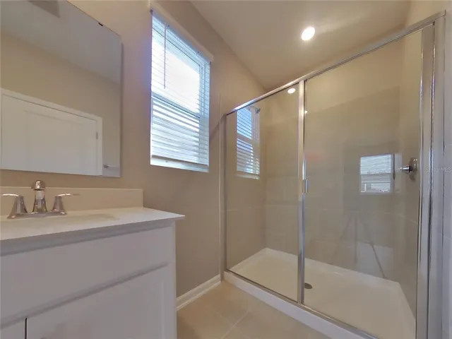 a bathroom with a shower sink vanity and mirror