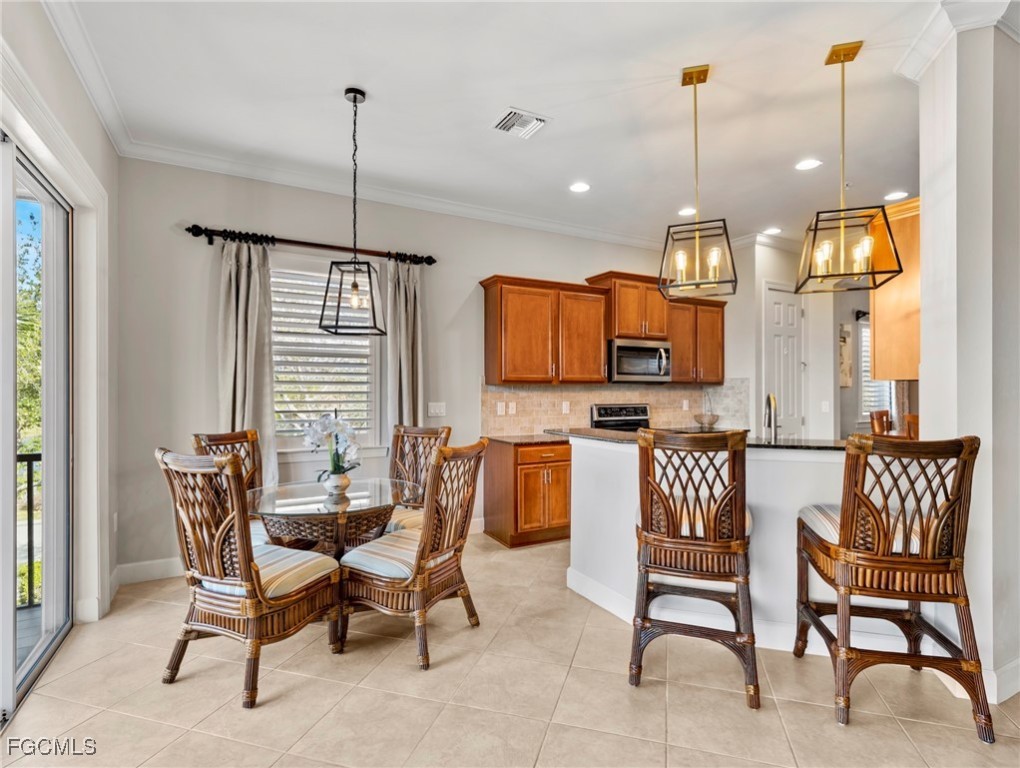12894 New Market Street, Unit 202 Fort Myers, FL 33913 - Photo 12 of 44 a view of a kitchen with a dining table chairs and a wooden floor