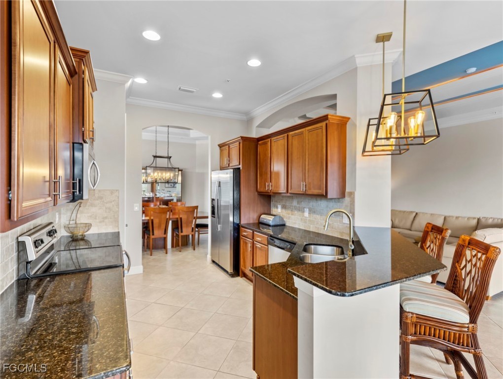 12894 New Market Street, Unit 202 Fort Myers, FL 33913 - Photo 14 of 44 a view of a kitchen with kitchen island granite countertop a sink and a refrigerator
