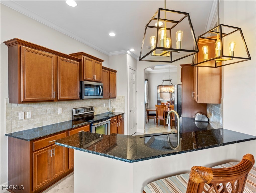 12894 New Market Street, Unit 202 Fort Myers, FL 33913 - Photo 16 of 44 a kitchen with stainless steel appliances granite countertop a sink a microwave cabinets and a dining table