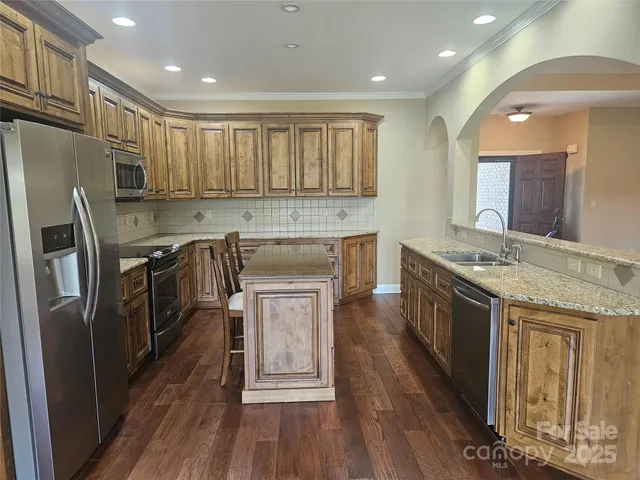 a kitchen with stainless steel appliances granite countertop a sink stove and refrigerator