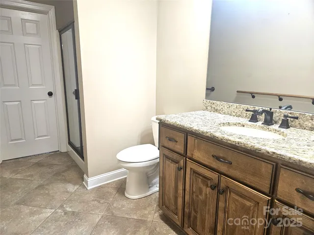 a bathroom with a granite countertop sink a toilet and a mirror