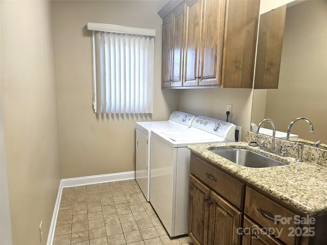 a utility room with sink dryer and washer