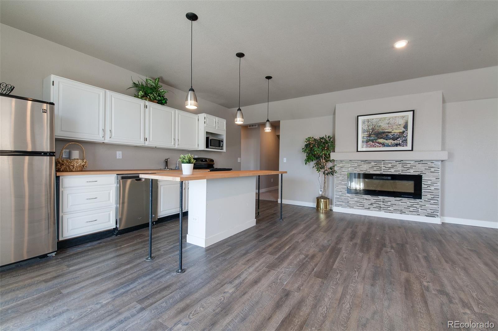 Undisclosed Address Castle Rock, CO 80104 - Photo 3 of 19 a open kitchen with cabinets a dining table and a fireplace