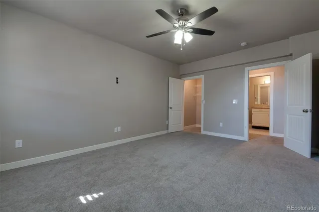an empty room with chandelier fan