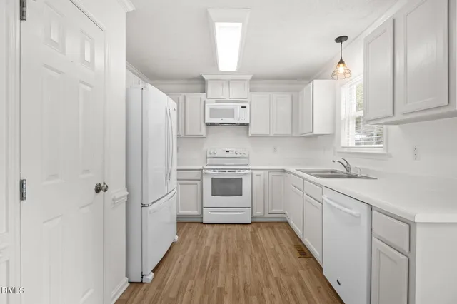 a kitchen with white cabinets and white appliances