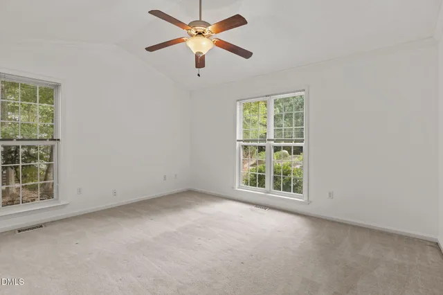 an empty room with closet and a ceiling fan
