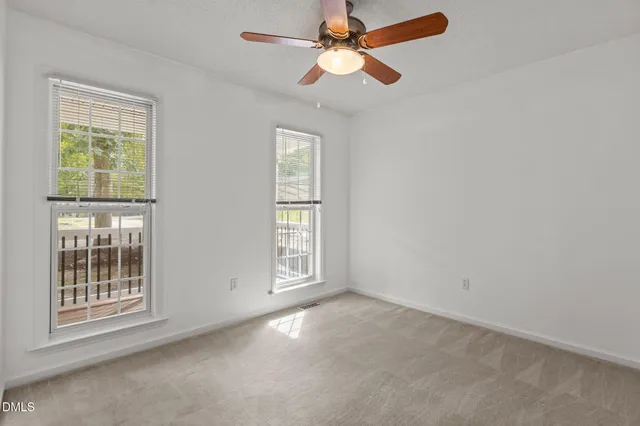 a view of an empty room with a ceiling fan