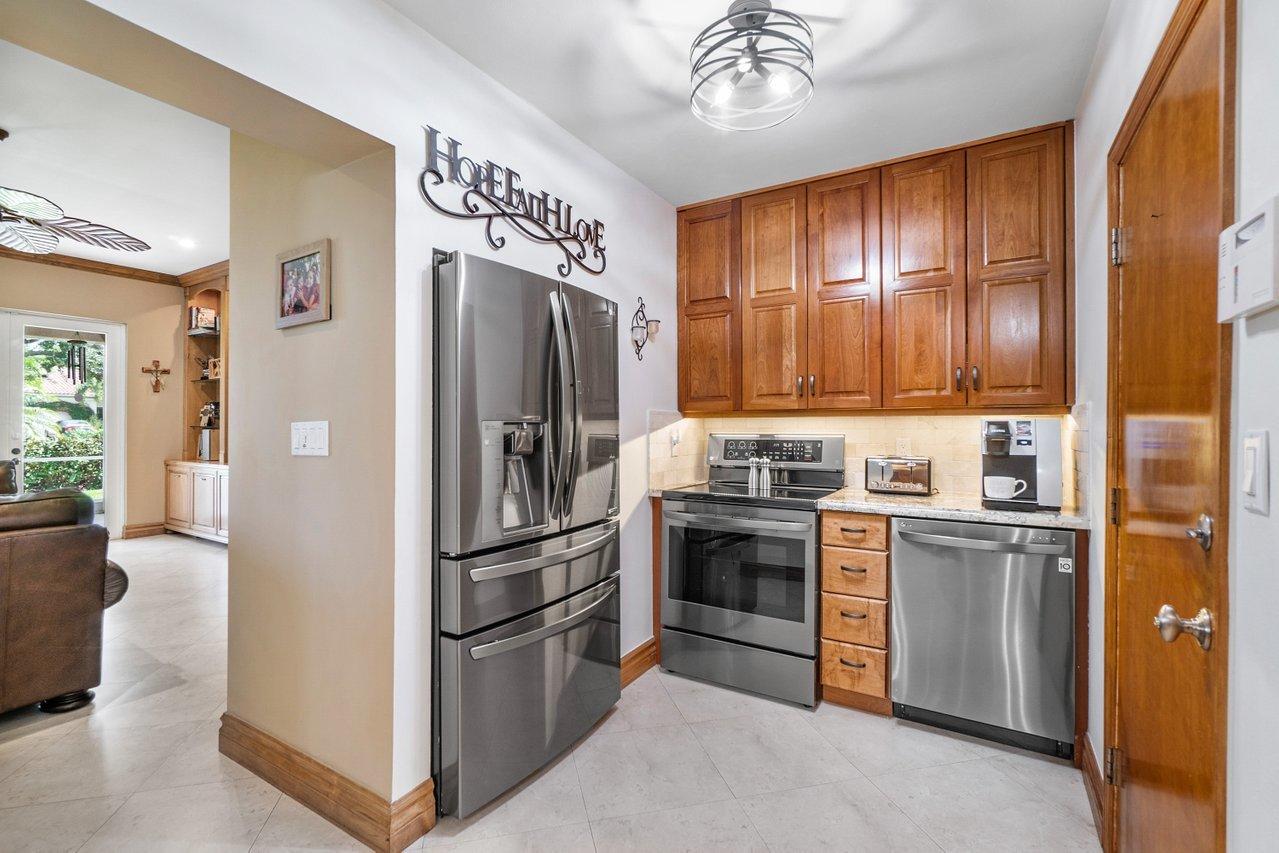 1018 Southwest 14th Street Boca Raton, FL 33486 - Photo 15 of 33 a kitchen with stainless steel appliances granite countertop a refrigerator and a stove top oven