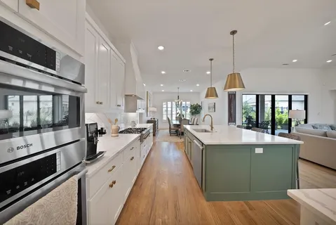 a large kitchen with stainless steel appliances kitchen island granite countertop a large counter top and stove