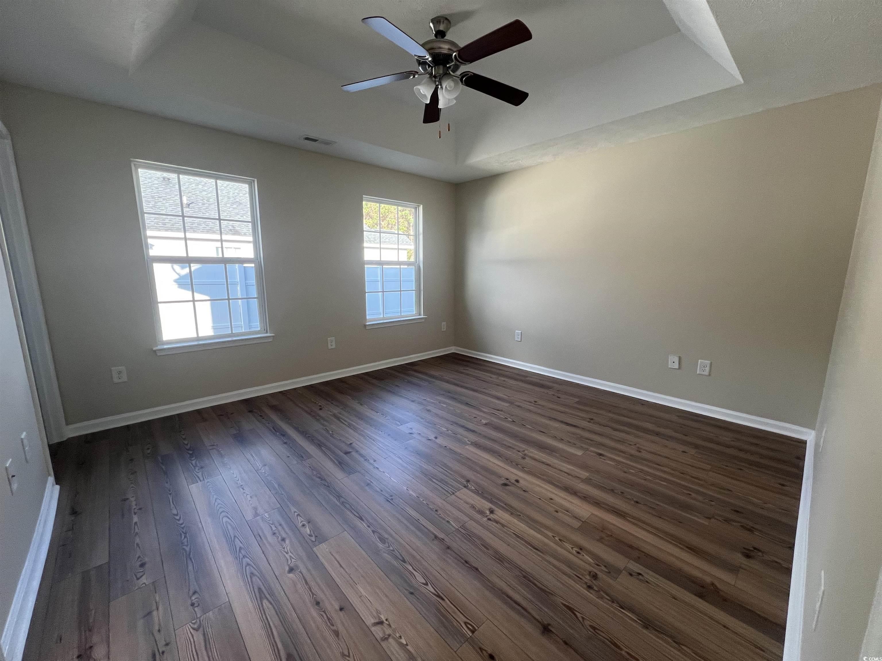225 Upper Saddle Circle Conway, SC 29526 - Photo 15 of 24 Spare room featuring a raised ceiling, dark wood-style flooring, and a ceiling fan
