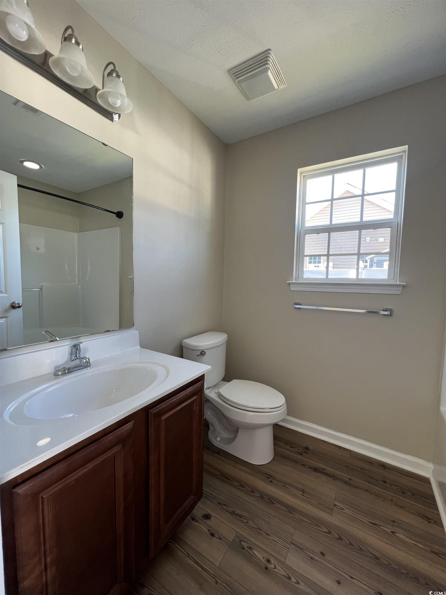 225 Upper Saddle Circle Conway, SC 29526 - Photo 16 of 24 Bathroom with vanity, dark wood-style flooring, bathing tub / shower combination, and a textured ceiling