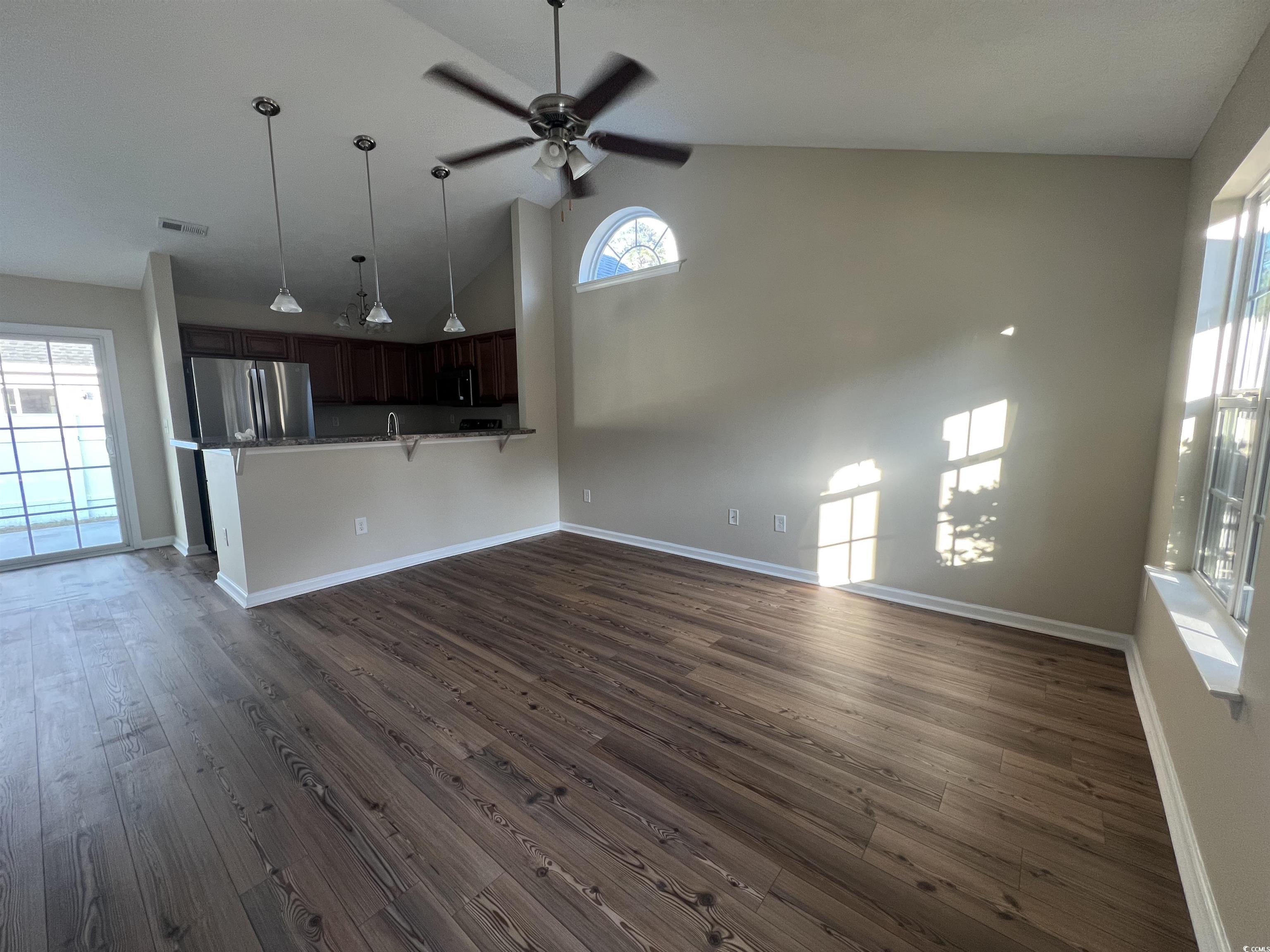 225 Upper Saddle Circle Conway, SC 29526 - Photo 4 of 24 Unfurnished living room featuring dark wood-style flooring, high vaulted ceiling, ceiling fan, and plenty of natural light