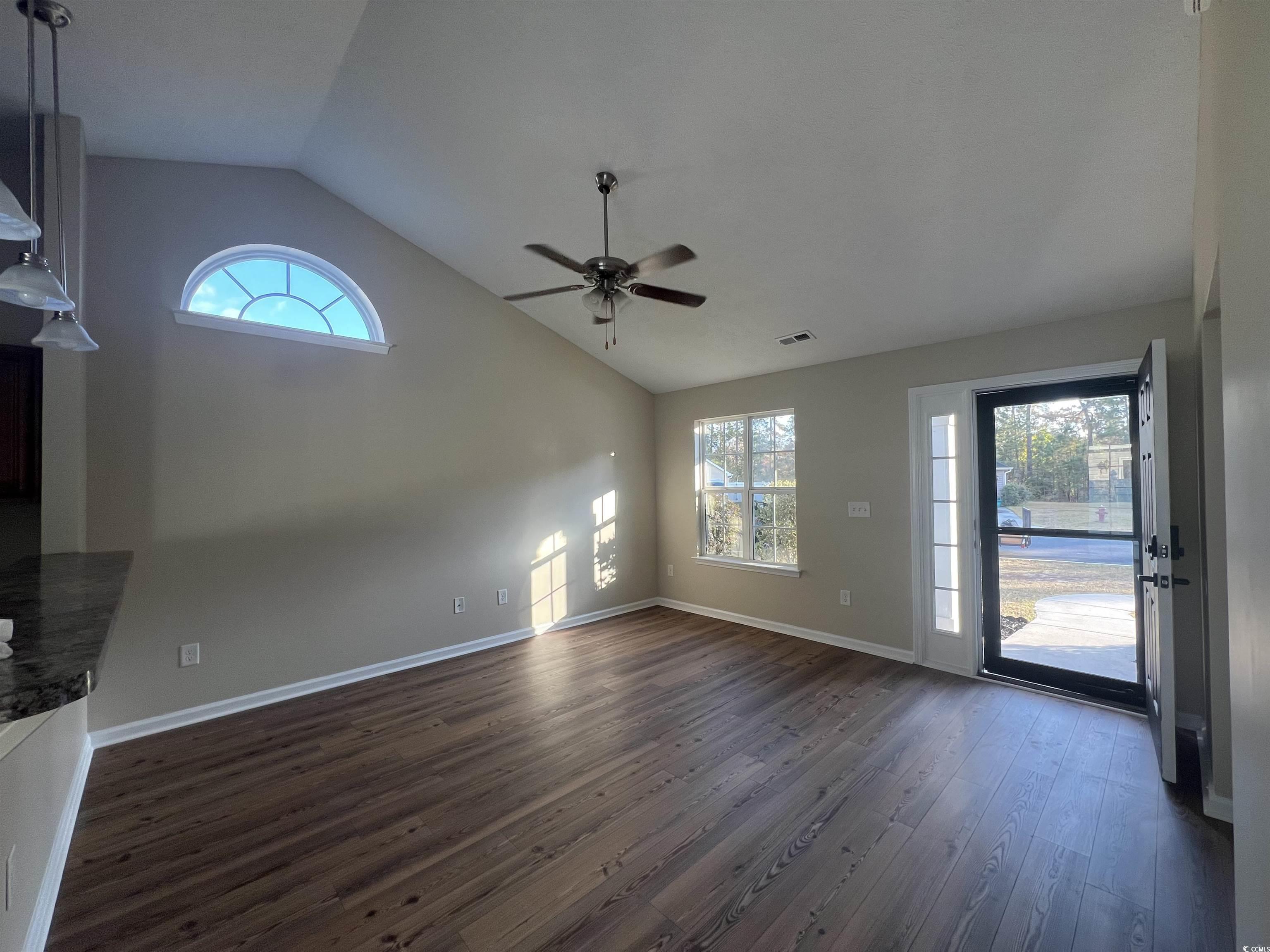 225 Upper Saddle Circle Conway, SC 29526 - Photo 5 of 24 Unfurnished living room with healthy amount of natural light, dark wood-type flooring, high vaulted ceiling, and a ceiling fan