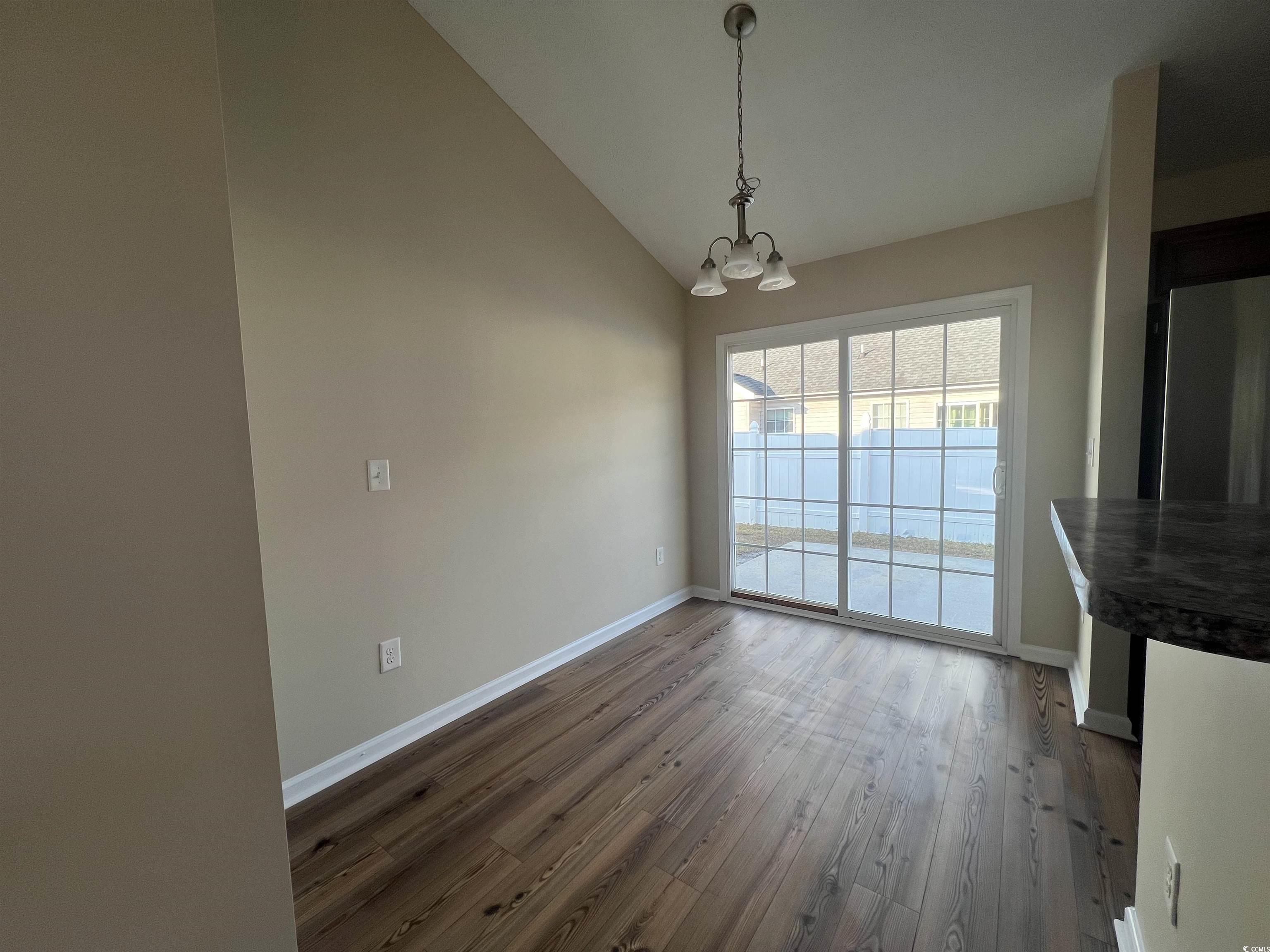 225 Upper Saddle Circle Conway, SC 29526 - Photo 7 of 24 Unfurnished dining area with dark wood-style flooring, a chandelier, and high vaulted ceiling