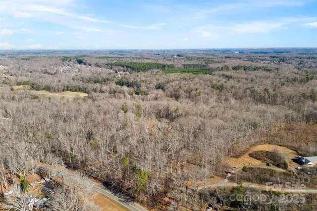 an aerial view of house with yard and mountain view in back