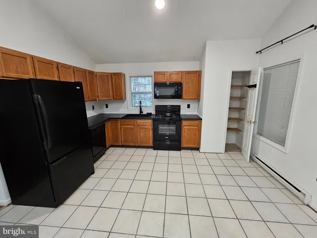 a kitchen with granite countertop a refrigerator and a stove top oven