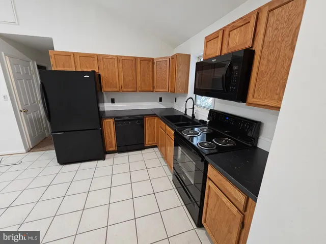 a kitchen with stainless steel appliances granite countertop a refrigerator stove top oven and sink