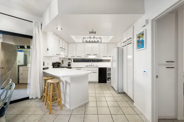 a kitchen with stainless steel appliances a stove a refrigerator and white cabinets with wooden floor