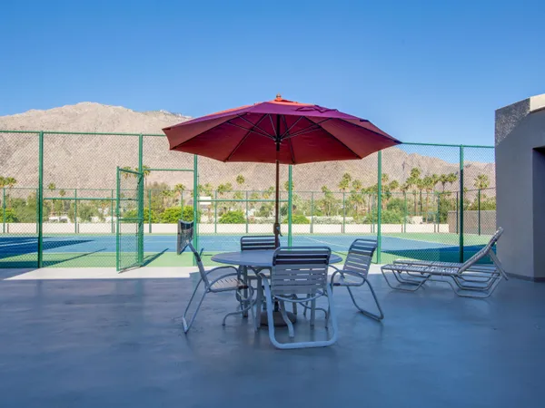 a view of a patio with table and chairs under an umbrella
