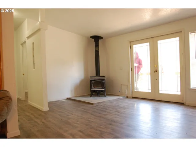 a view of a hallway with wooden floor and a bathroom
