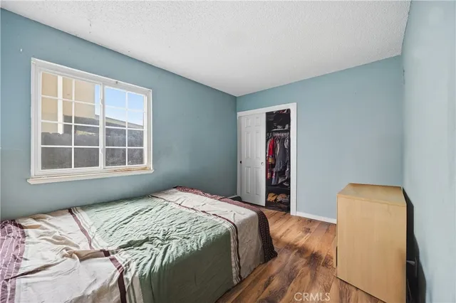 a bedroom with a bed and wooden floor