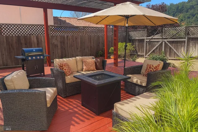 a view of an outdoor sitting area with furniture and umbrella