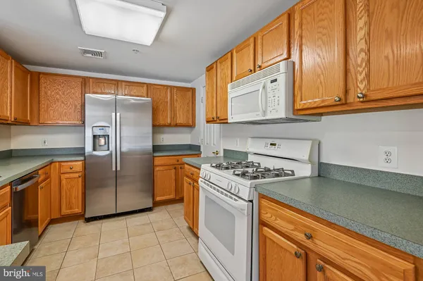 a kitchen with stainless steel appliances granite countertop a refrigerator a stove and a sink