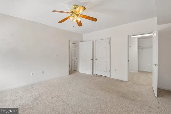 an empty room with a ceiling fan and a window