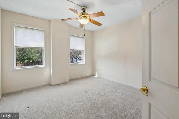 an empty room with a window and a ceiling fan