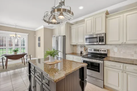 a kitchen with stainless steel appliances granite countertop a kitchen island hardwood floor and a sink