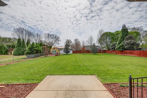 a view of yard with swimming pool and green space