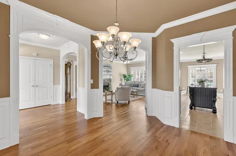 a view of a livingroom with wooden floor and a dining table