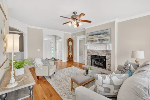 a living room with furniture a fireplace and a chandelier