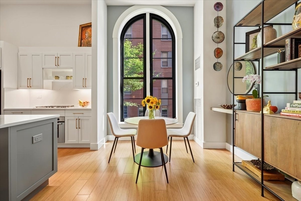 21 Father Francis Gilday Street, Unit 114 Boston, MA 02118 - Photo 2 of 28 a dining room with furniture a floor to ceiling window and wooden floor