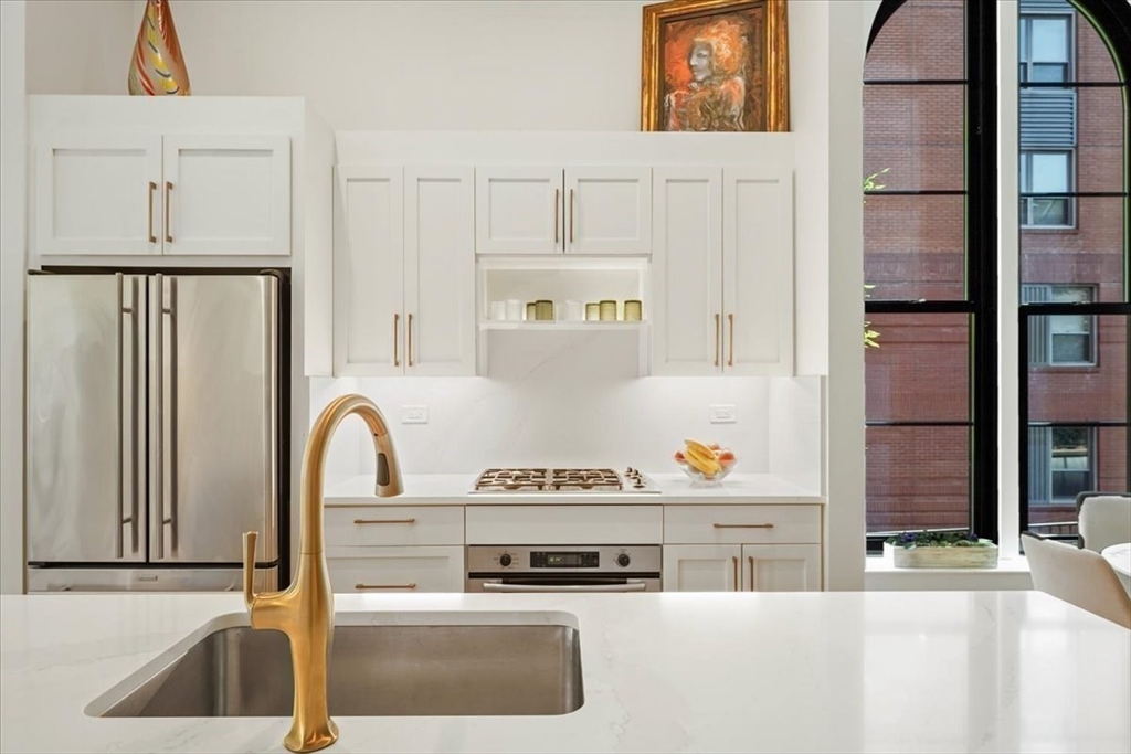 21 Father Francis Gilday Street, Unit 114 Boston, MA 02118 - Photo 4 of 28 a kitchen with stainless steel appliances granite countertop a sink and a refrigerator