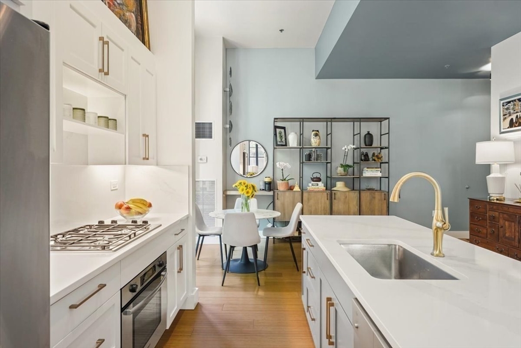 21 Father Francis Gilday Street, Unit 114 Boston, MA 02118 - Photo 5 of 28 a kitchen with a sink stove and cabinets