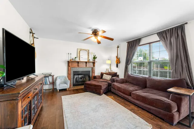 a living room with furniture a flat screen tv and a large window